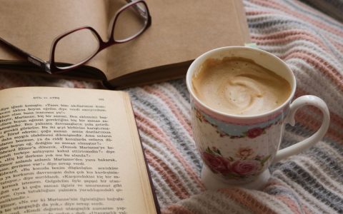 Warm scene of enjoying coffee and books, creating a cozy and relaxing atmosphere.