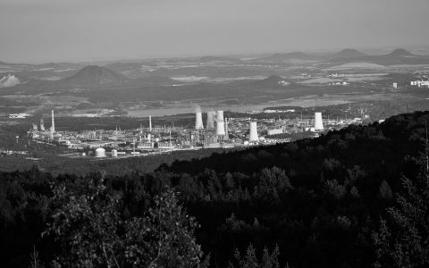 Black and white aerial photo of a vast industrial plant set in a rural landscape.