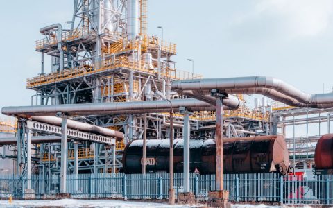 Oil refinery facility with tanker wagons in Trzebinia, Lesser Poland Voivodeship under a clear sky.