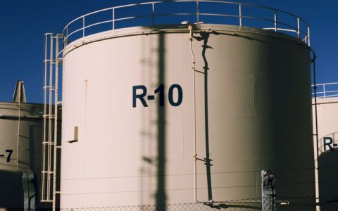 Large industrial storage tanks under blue skies, highlighting metal structures.