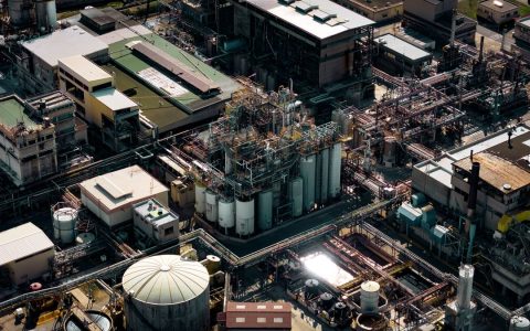Aerial shot of a bustling industrial area in Marseille, France, showcasing silos and pipes.