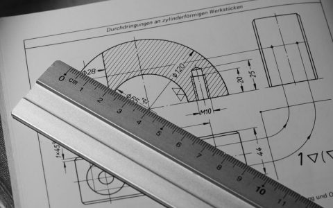Black and white image of technical drawing with metal ruler, ideal for engineering concepts.