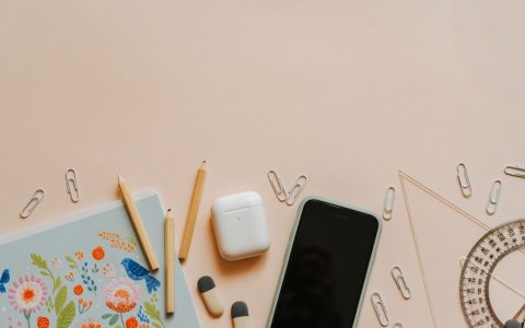 A top-down view of school supplies and tech gadgets on a desk, ideal for education themes.