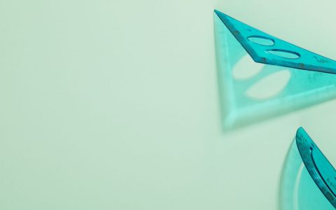 Abstract view of blue transparent set squares on a mint background.