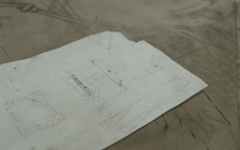 Antique sketches of blacksmith tools and designs on worn paper.