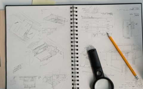 Detailed architectural sketches with drawing tools on a desk, perfect for design projects.