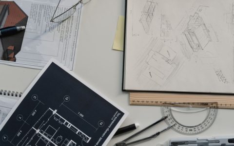 Creative workspace with architectural sketches, blueprints, and drawing tools, perfect for planning and design.