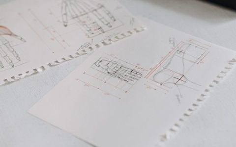 Close-up of detailed technical drawings on neatly arranged white paper sheets, highlighting design concepts.