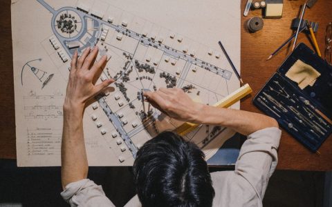 Top view of an architect working on a design project with precision tools.
