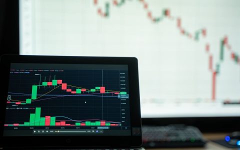 Close-up of a laptop showing cryptocurrency market charts in a trading environment.