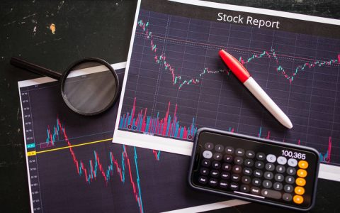 Stock report with charts, calculator, and magnifying glass for financial analysis.