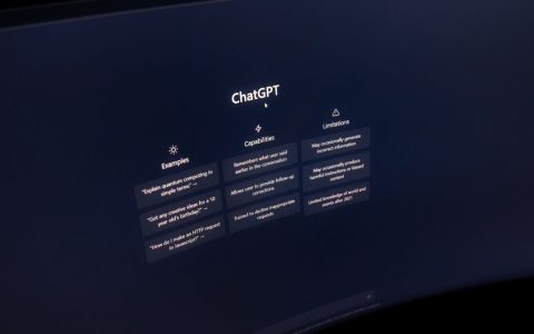 Close-up of a computer screen displaying ChatGPT interface in a dark setting.