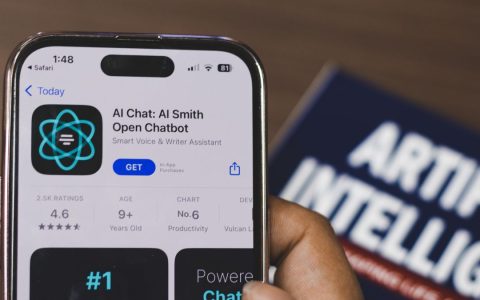 Hand holding a smartphone with AI chatbot app, emphasizing artificial intelligence and technology.