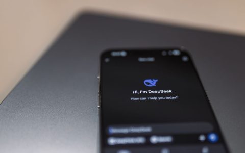 Close-up of a smartphone with AI assistant interface on screen over a laptop.