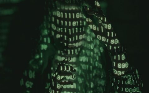 An unrecognizable person with binary code projected, symbolizing cybersecurity and digital coding.