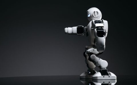 A white robot showcasing modern design on a sleek dark surface.