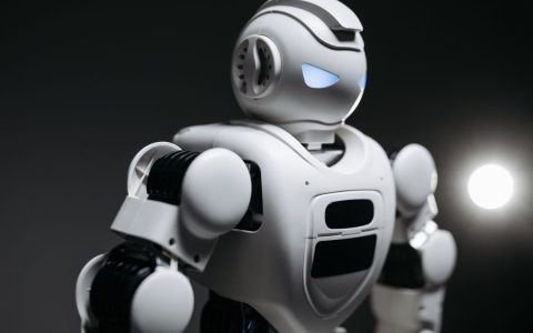 High-detail close-up image of a white robot with glowing eyes in studio lighting. Modern tech innovation.