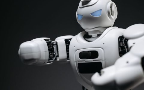 Detailed close-up of a high-tech white robot in a studio setting with a gray background.
