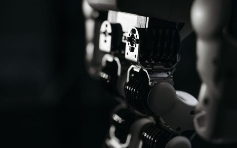 Detailed close-up of a robot's mechanical components, emphasized by moody studio lighting.