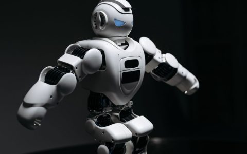 Close-up of a futuristic humanoid robot under dramatic lighting in dark ambiance.