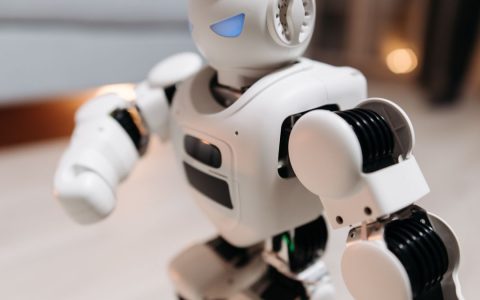 Close-up of a futuristic toy robot with blue eyes, showcasing modern technology indoors.