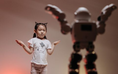 Child interacting with futuristic robot in a playful setting, showcasing modern technology.