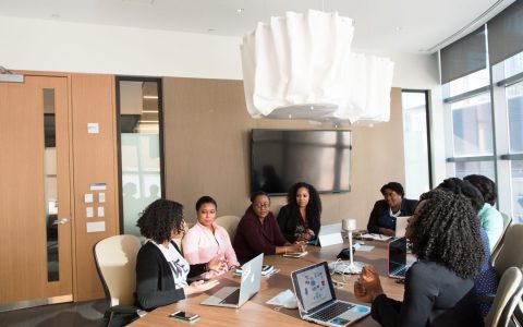 Group of professionals engaged in a strategic meeting in a modern office setting.