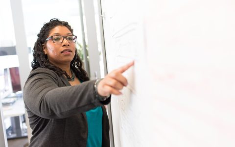 Confident businesswoman making a point during a presentation in an office setting.