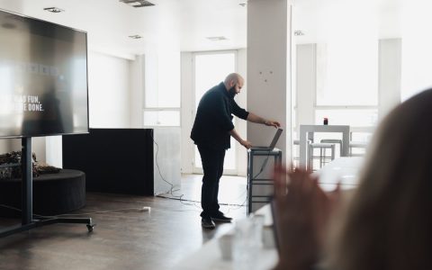 Professional presentation setting with a screen and laptop, captured indoors.