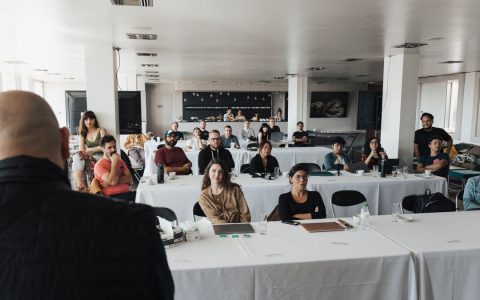 A diverse group of business professionals attending a presentation in a modern conference room.