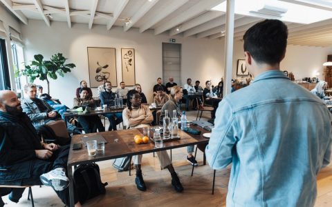 A diverse group attending a business presentation in a modern, well-lit conference room.