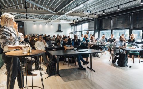 A lively business workshop engaging a diverse audience in a modern conference room.
