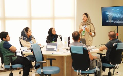 Group of professionals collaborating in an office meeting with presentations.