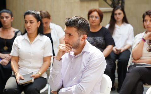 Group of people engaged in a business meeting discussion outdoors.