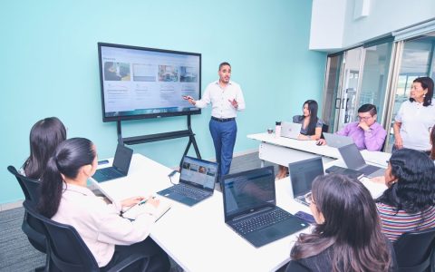 Team engaged in a presentation at a modern office using digital technology.