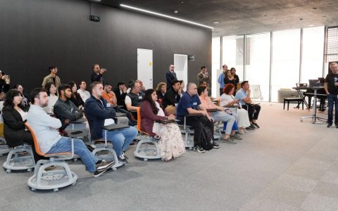 Diverse group attending business presentation in modern conference room setting.