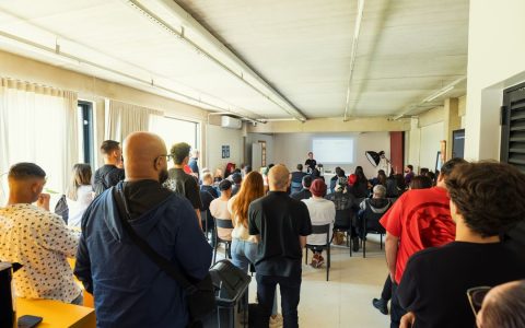 A diverse group attending a seminar in a bright, modern indoor setting.