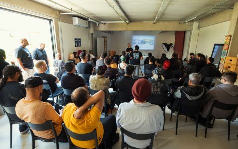 Group of diverse adults attending a business seminar in a modern indoor setting, discussing key insights.