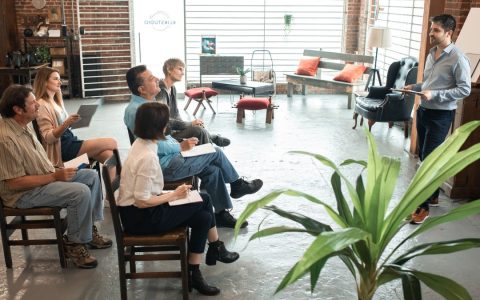 Diverse group of adults engaged in a workshop session inside a trendy loft.