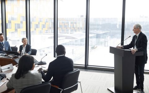Corporate professionals engaged in a formal business meeting in a modern conference room setting.