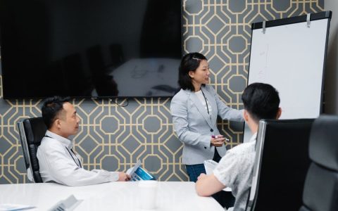 A professional conducting a presentation in a modern office space with colleagues engaged.
