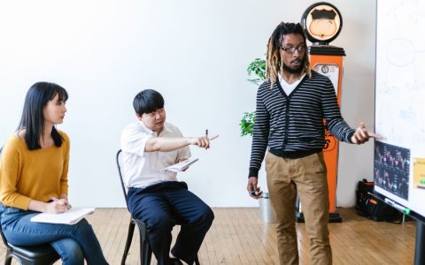 A diverse group of adults in a learning session, actively engaging with a presentation.