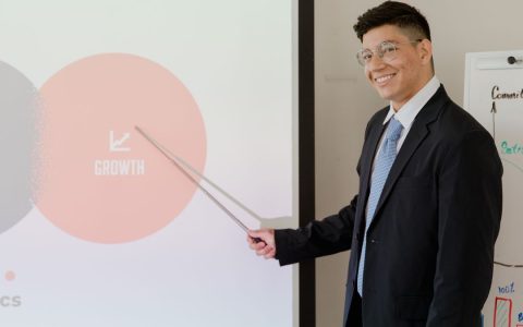 Smiling businessman presenting growth strategy in a modern meeting room.