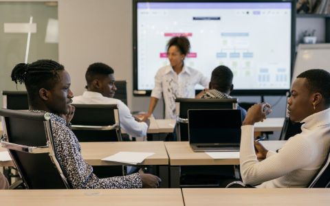 A diverse group of professionals in an interactive meeting with digital presentation tools.